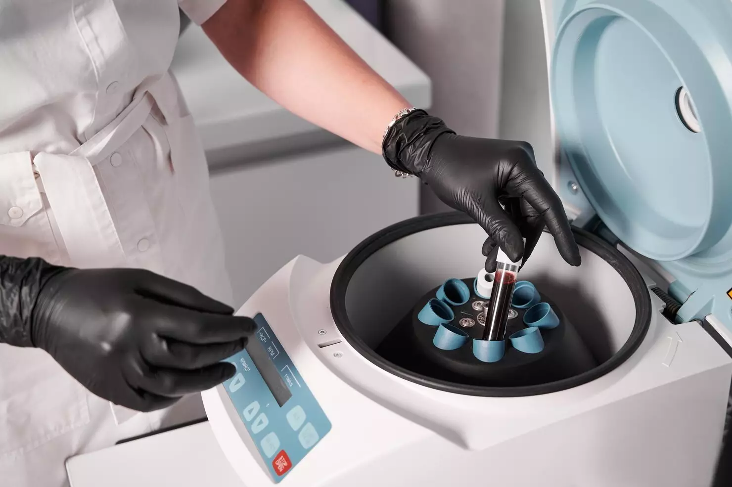 researcher-putting-test-tube-into-laboratory-centrifuge_651396-2196